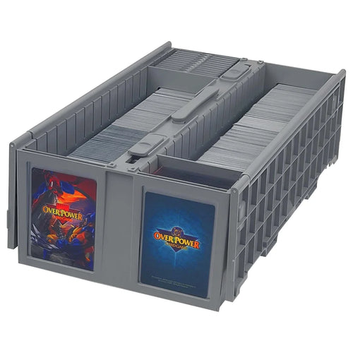A BCW gray plastic card storage organizer with two front windows displaying card decks. The left window shows a red and blue 'Overpower' card deck, and the right window shows a blue card deck with the 'Overpower' logo.