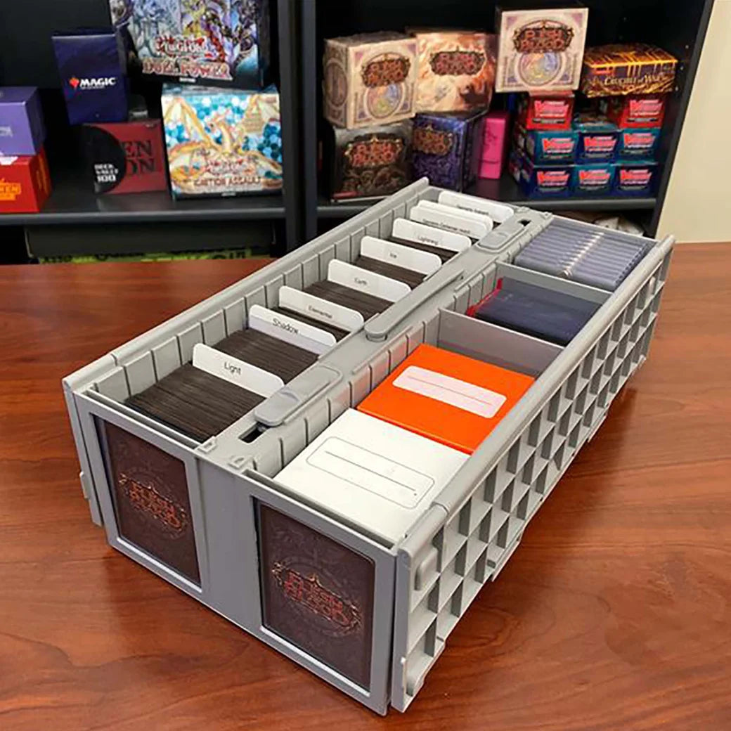 BCW card organizer with compartments on a wooden surface, with card boxes in the background.