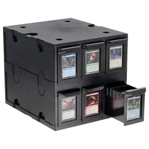 A black plastic Magic: The Gathering BCW card box with six front compartments, three closed and three open, displaying sample collectible cards. One drawer on the right is pulled open, showing a card inside.