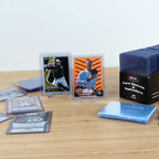 Collection of sports trading cards on a wooden surface with BCW card sleeves packaging.